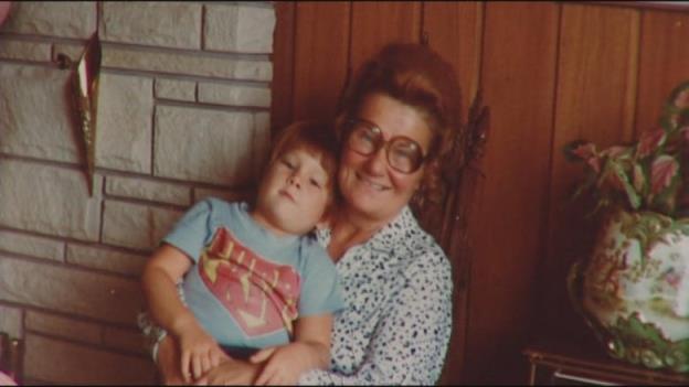 A young child is sitting on the lap on an elderly woman.